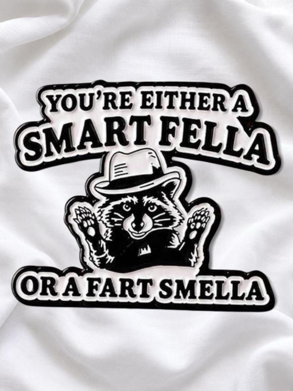Enamel pin with 'You're Either a Smart Fella or a Fart Smella'